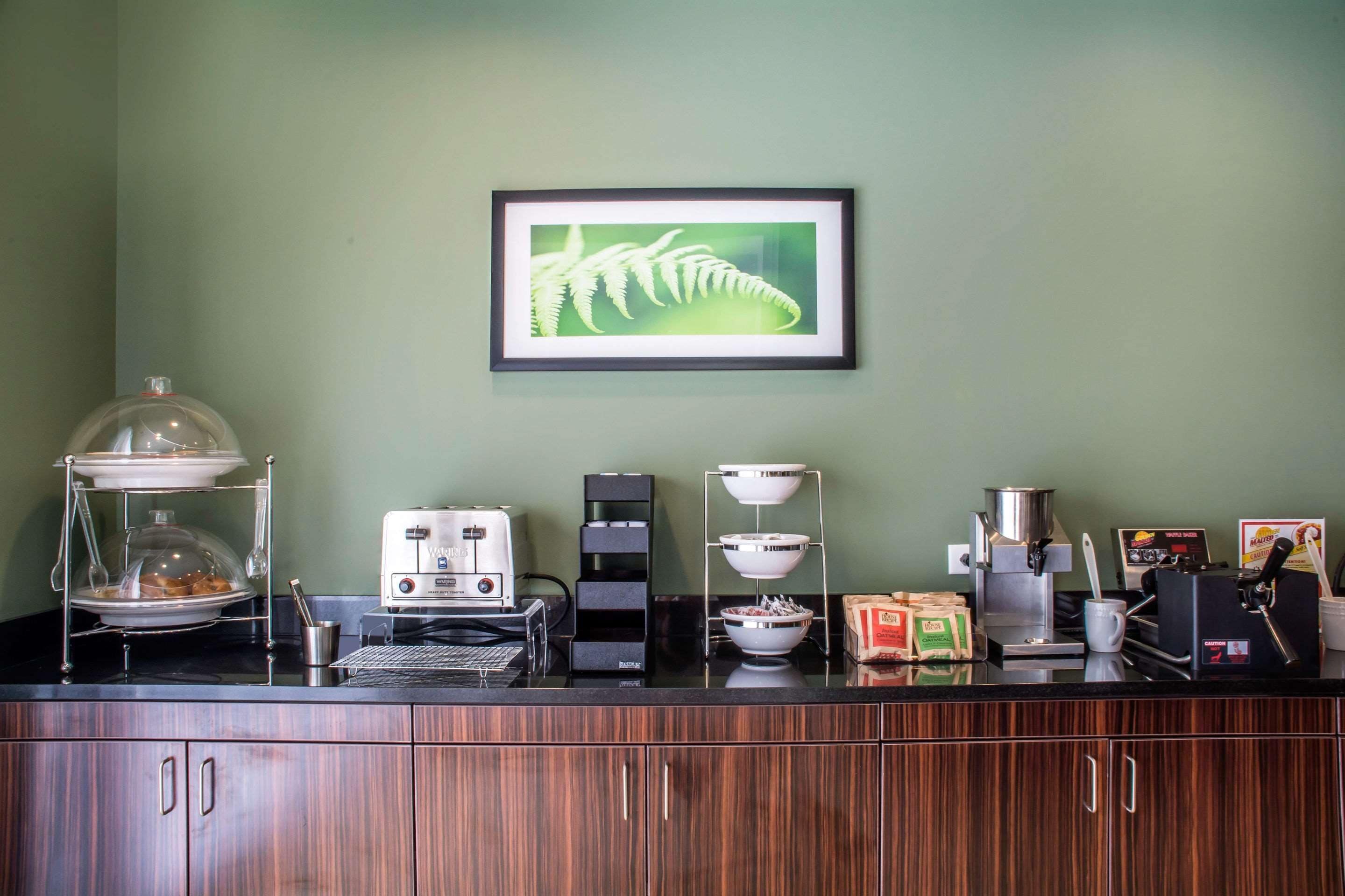 A coffee station with a coffee maker, a scale, and a display of coffee beans.