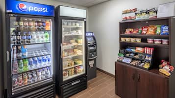 A vending machine area with a Pepsi cooler, an ATM, and snack shelves.