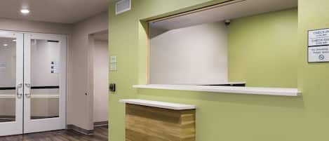 A reception area with a check-in/check-out counter, a sign indicating smoking is not allowed, and a sign for room 101.