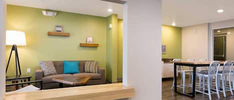 Una sala de estar moderna con un sofá, una mesa de centro y un comedor con sillas y una mesa.