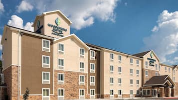 Ein mehrstöckiges Hotel mit einem Schild für 'Woodspring Suites Signature'.