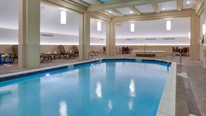 An indoor swimming pool with clear blue water, lounge chairs, and a sunlit ceiling. - Drury Plaza Hotel Pittsburgh Downtown (Pittsburgh)