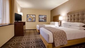 A hotel room with a large bed, a television, two framed pictures on the wall, and a patterned carpet. - Drury Plaza Hotel Pittsburgh Downtown (Pittsburgh)