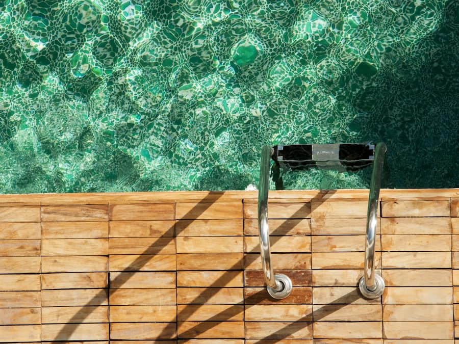 Una piscina al aire libre, sillones reclinables de piscina