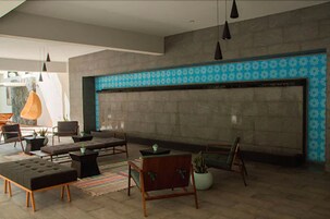 Una sala de estar moderna con chimenea, asientos cómodos y una pared con diseño.