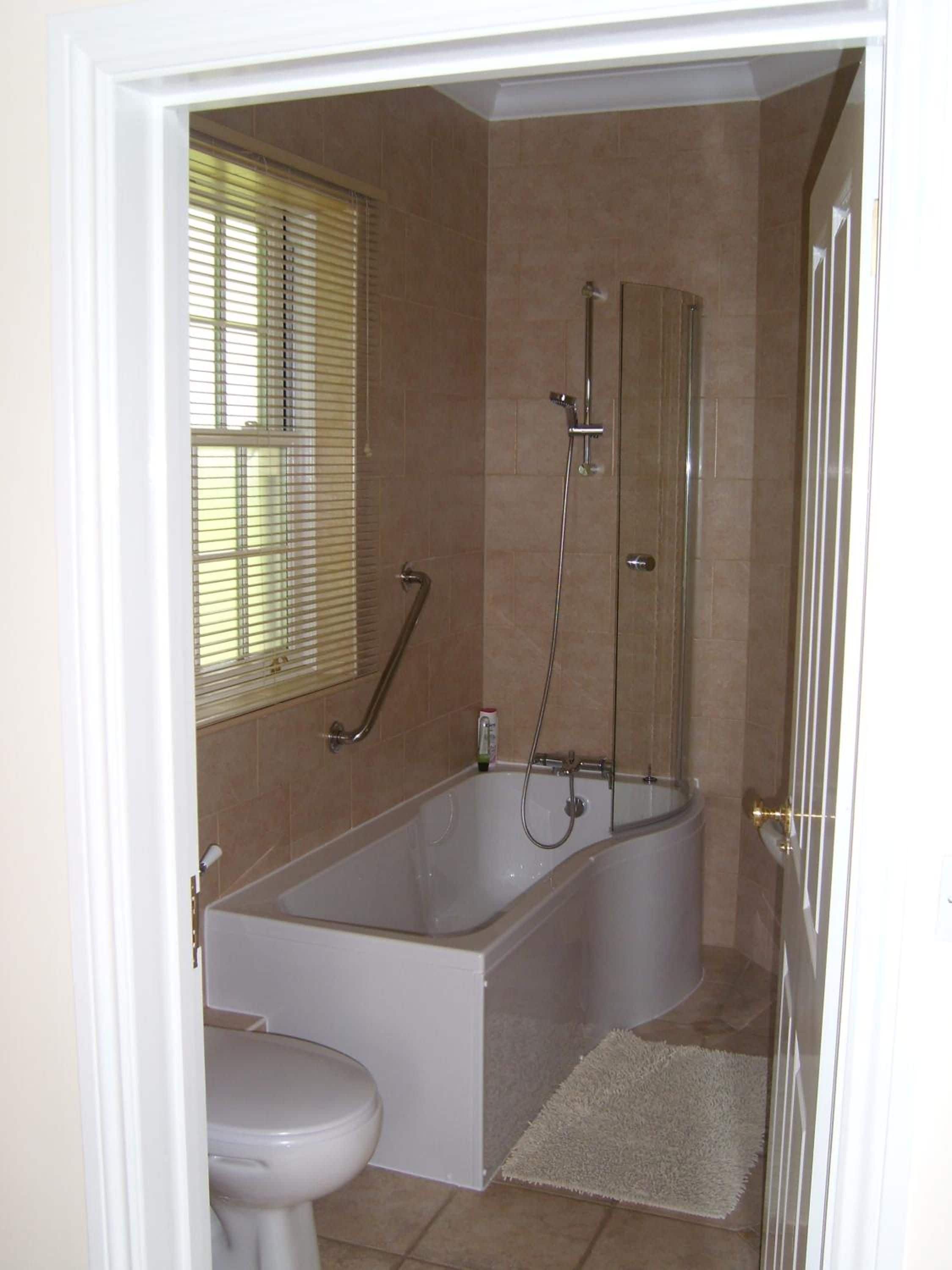 Un baño con bañera, inodoro y zona de ducha.