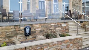 A building with stone walls, a staircase, outdoor seating, and a sign reading "Geckos Rest". - Geckos Rest (Newquay)