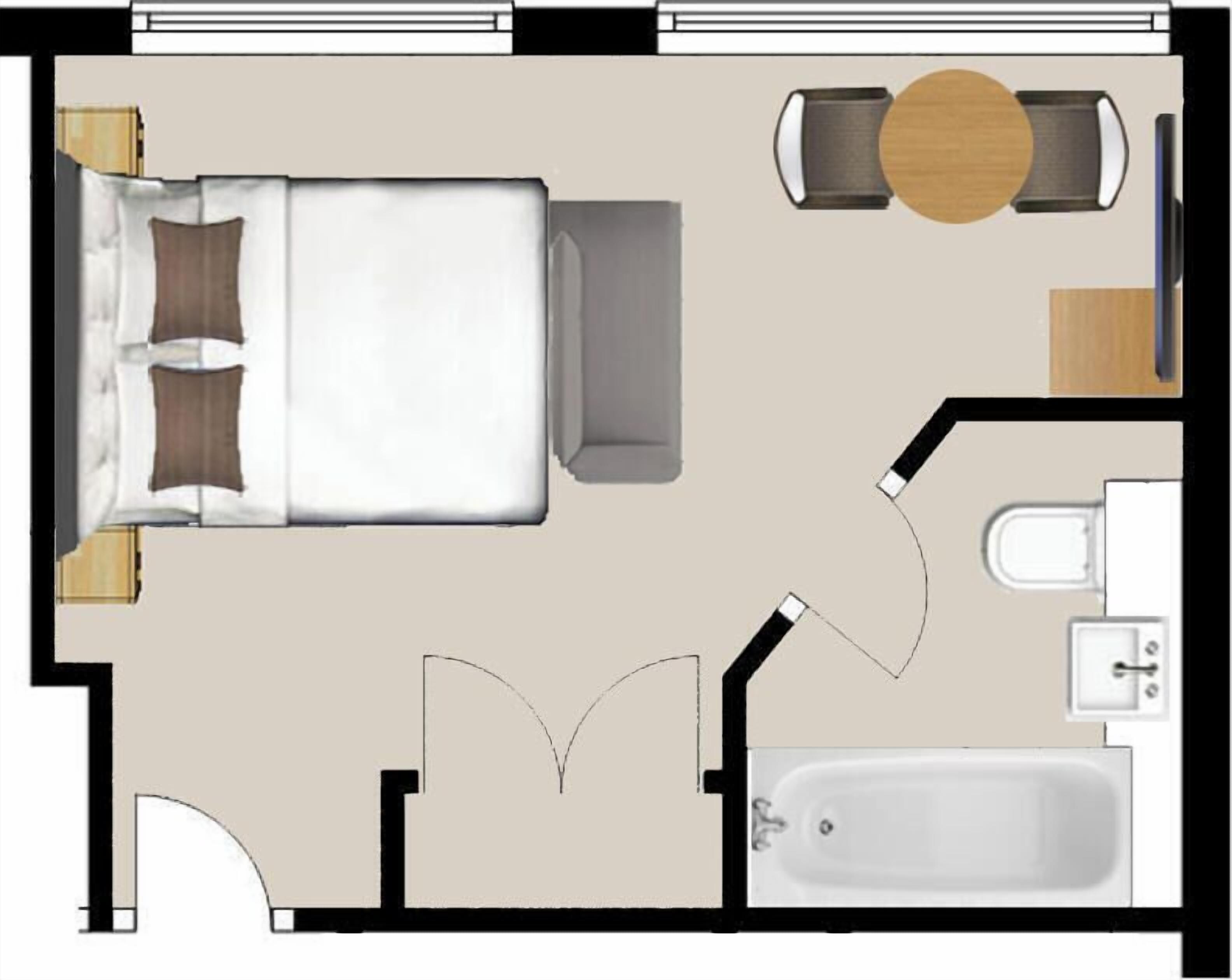 Il y a une chambre à coucher avec un lit, une table de chevet et une chaise. On y trouve également une salle de bain équipée de toilettes, d’un lavabo et d’une baignoire. On aperçoit aussi un coin repas avec une table et des chaises.