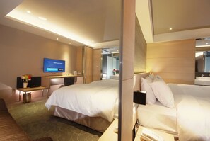 A hotel room with two beds, a desk with a flat-screen TV, a small table with a vase of flowers, and a mirror on the wall. - Guest Hotel (Taipei)