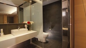 A modern bathroom with a large mirror, a white sink, and a glass shower enclosure. - Guest Hotel (Taipei)