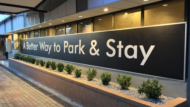 Un cartel con el texto 'A Better Way to Park & Stay' en la fachada de un edificio.