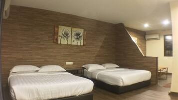 Quarto de hotel com duas camas, paredes de madeira e uma pequena mesa.
