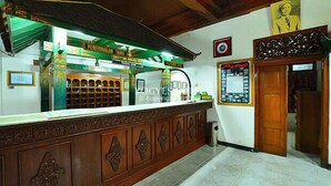 Zona de recepció amb taulell, certificats emmarcats i una paret amb una fotografia emmarcada.