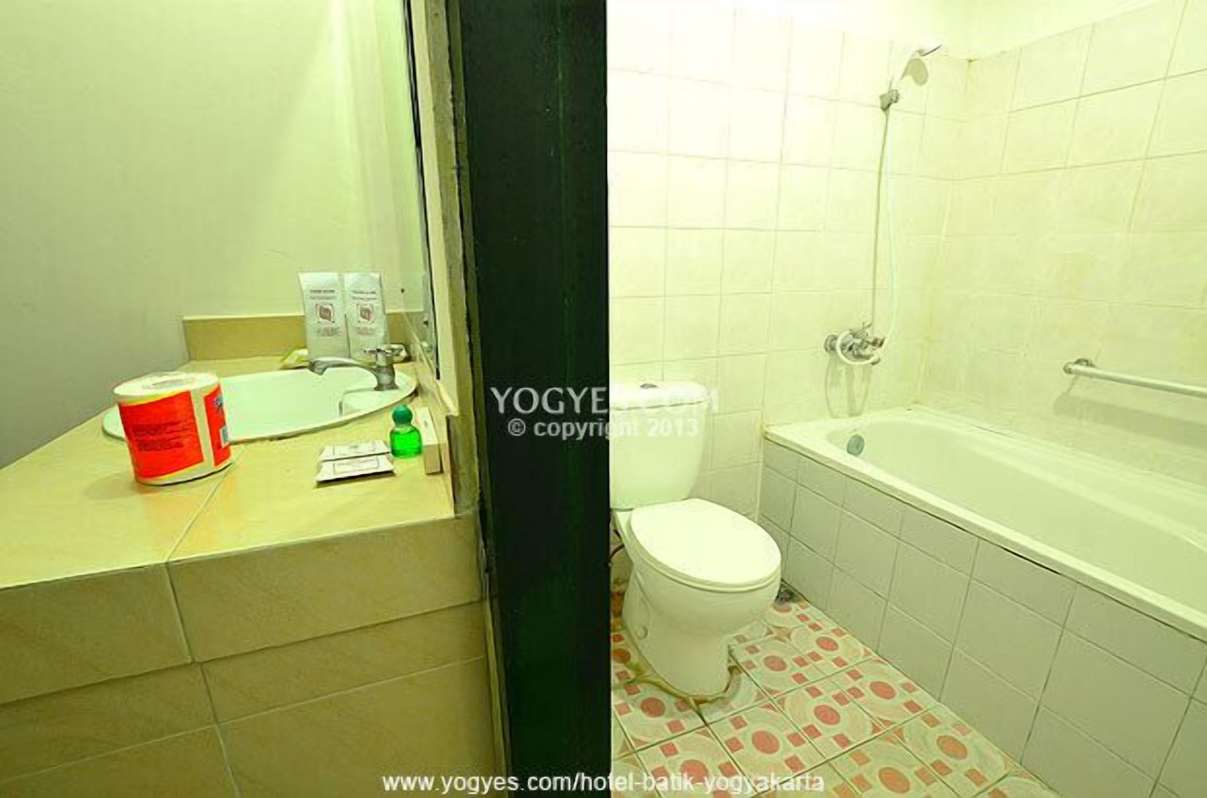 Een badkamer met toilet, wastafel en bad.