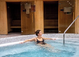 Una piscina techada, sillones reclinables de piscina