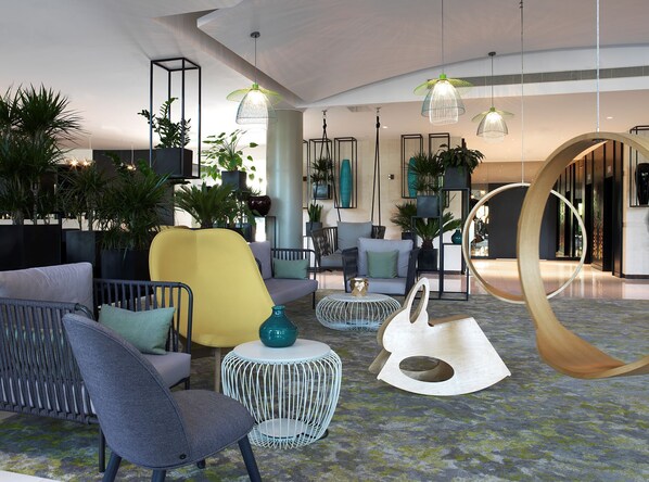 A modern lobby with seating, plants, and unique lighting fixtures. - The Jangle Hotel Paris Charles de Gaulle Airport (Le Mesnil-Amelot)