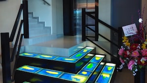 A staircase with glass panels and a floral arrangement.