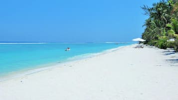 Am Strand, Sonnenschirme, Strandtücher, Wasserski