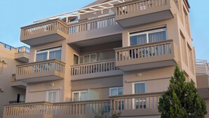 A multi-story residential building with balconies, large windows, and a flat roof. - Pantheon Apartments (Chania)