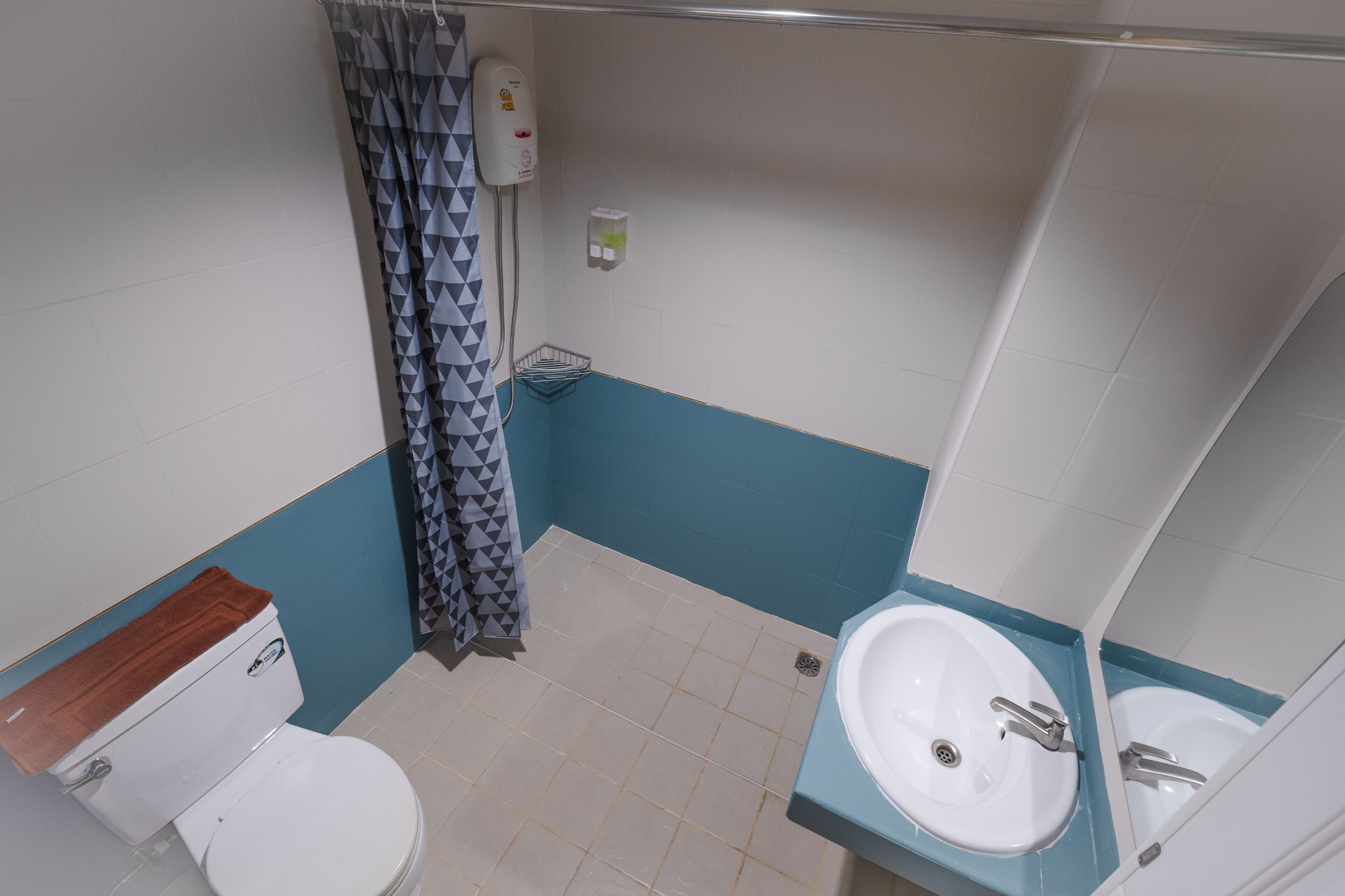 A bathroom with a toilet, a sink, and a shower area.