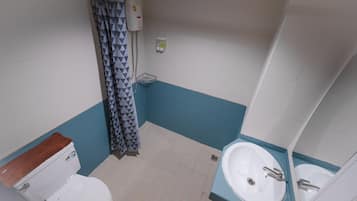 Un bagno con il water, un lavandino e una zona doccia.