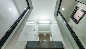 A modern, clean stairwell with white tiled walls and a central handrail. - Don Muang Hotel (Bangkok)