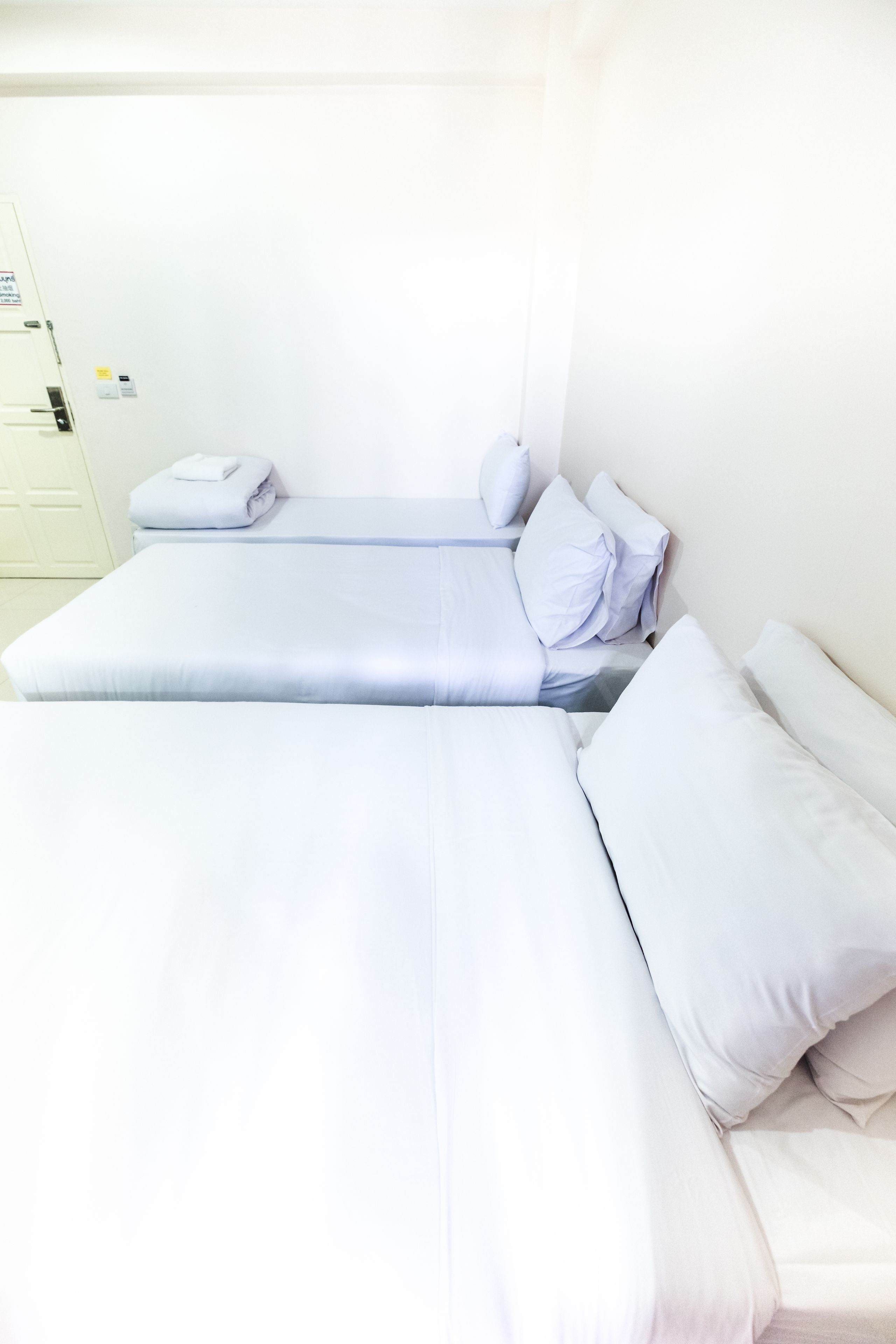 A room with two single beds, each with white bedding and pillows.