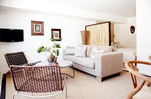 A modern living room with a sofa, a coffee table, and a TV mounted on the wall. - The Odyssey 404 (Cape Town)