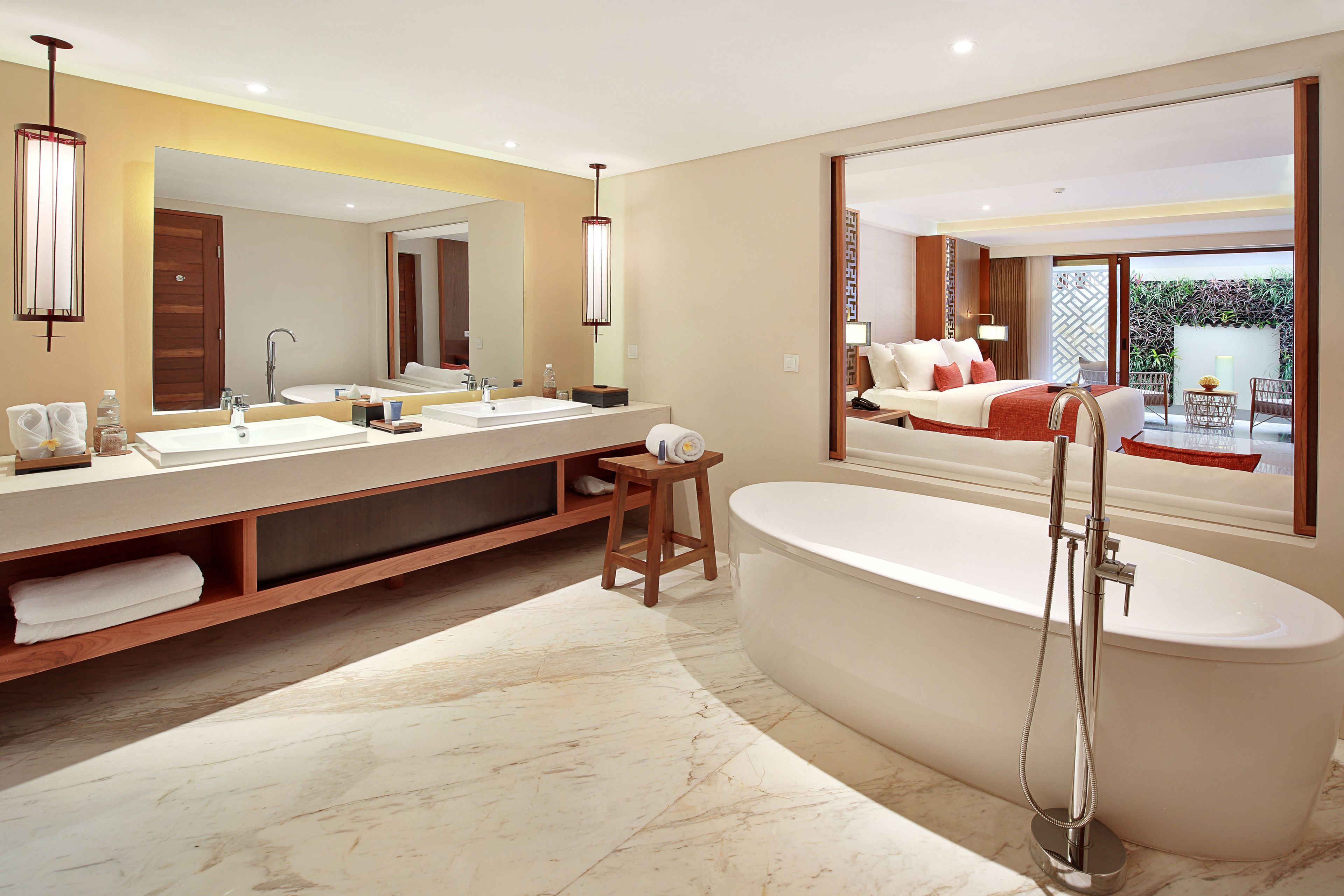 A modern bathroom with a large bathtub, a double sink vanity, and a large mirror.