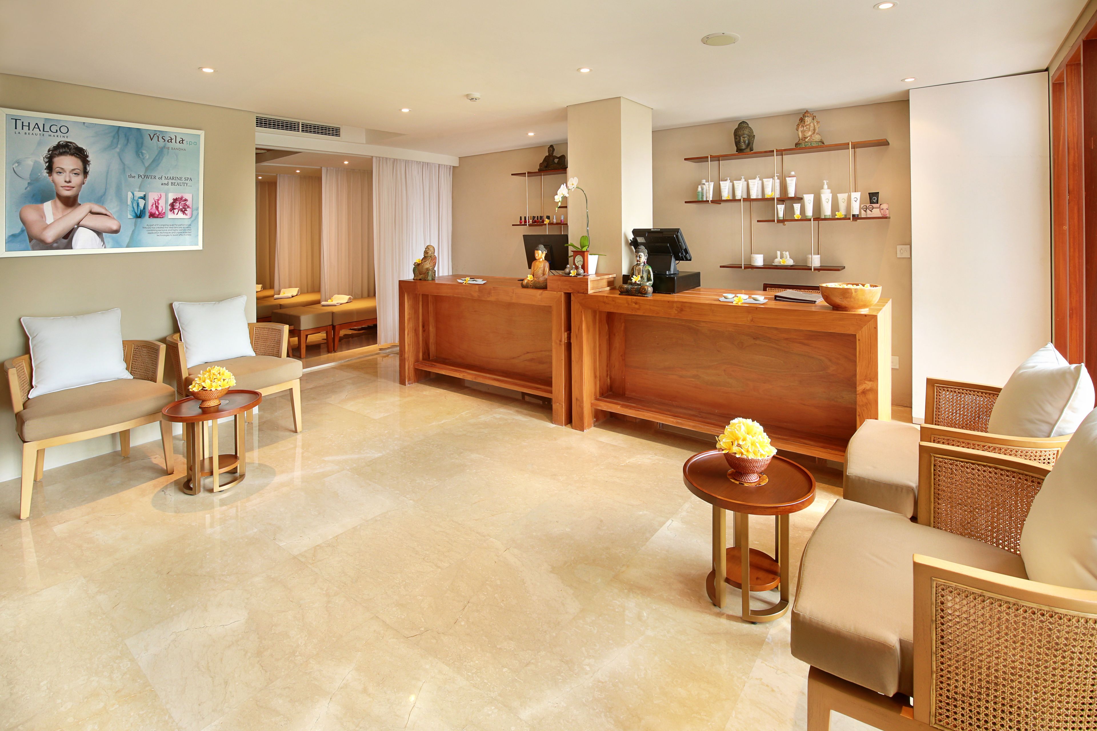 A hotel lobby with seating areas, a reception desk, and a wall-mounted advertisement.