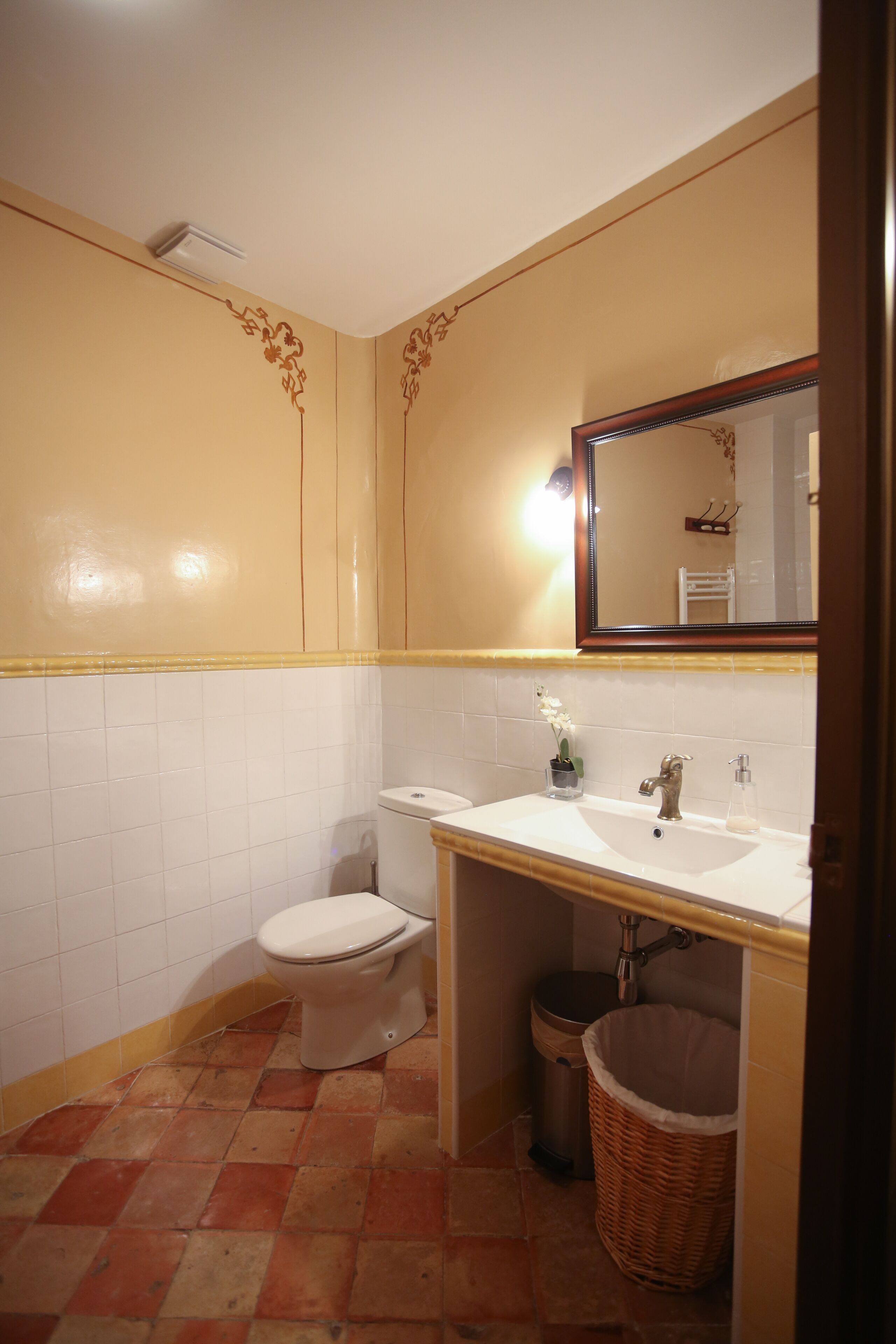 Un baño con inodoro, lavamanos y espejo.