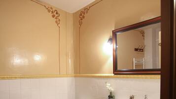 Un baño con inodoro, lavamanos y espejo.