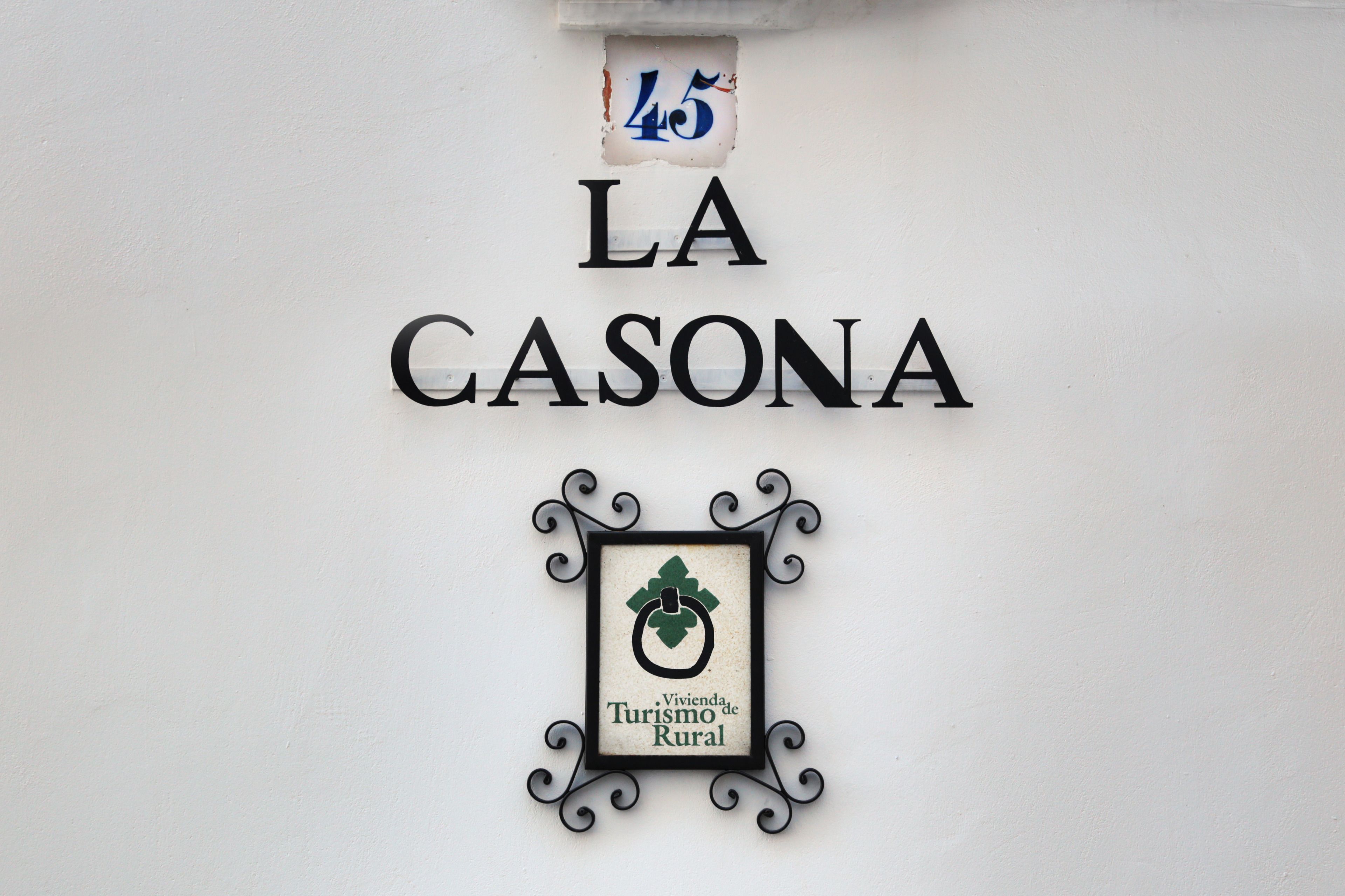 Et skilt med "LA CASONA" og et logo for "Vivienda Turismo de Rural".