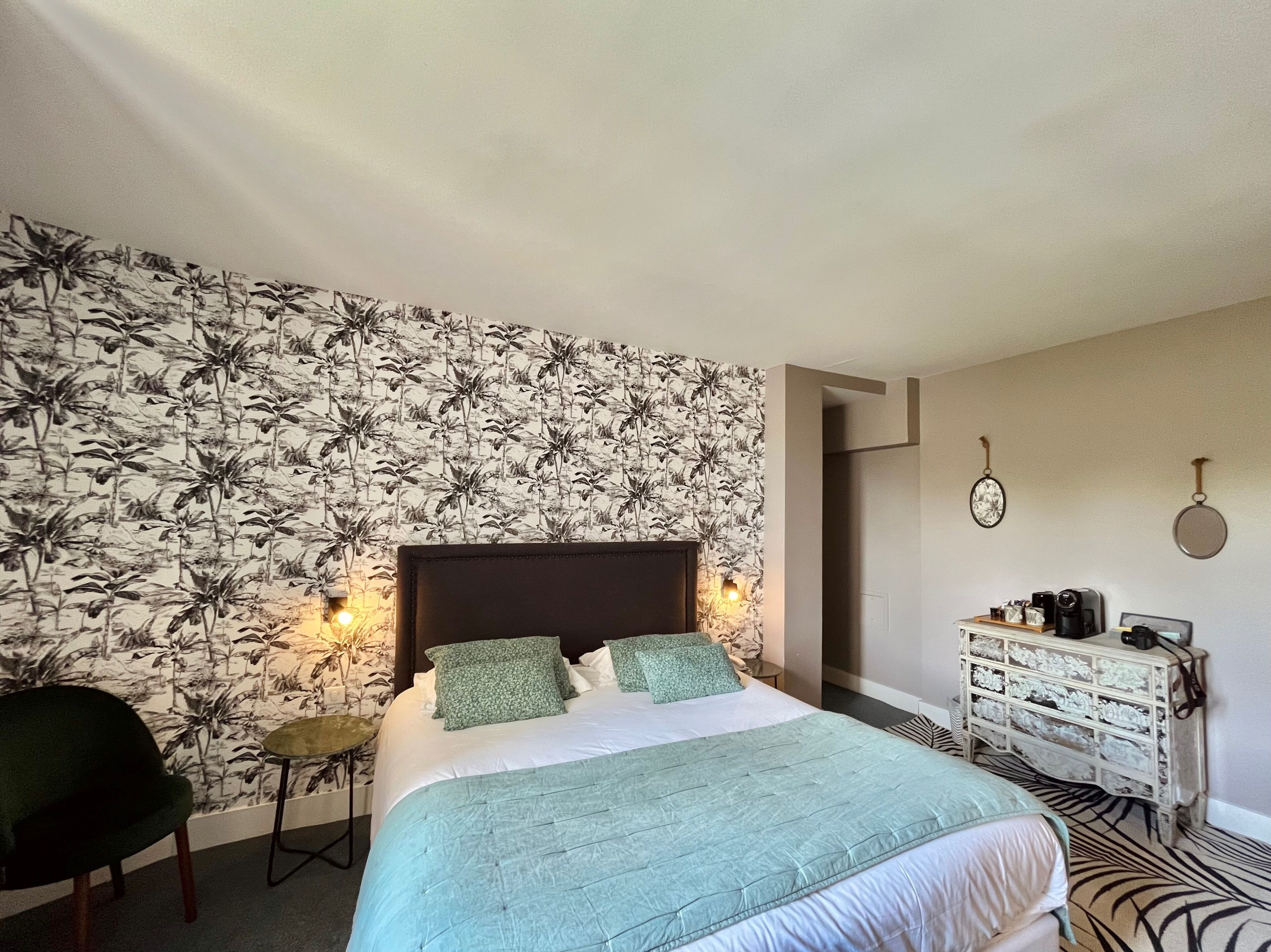 A bedroom with a bed, a nightstand, a dresser, and a chair.