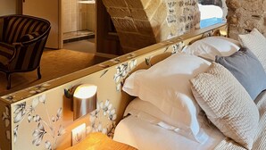 A bedroom with stone walls, a wooden bed, and a chair. - Hôtel des Basses Pyrénées (Bayonne)