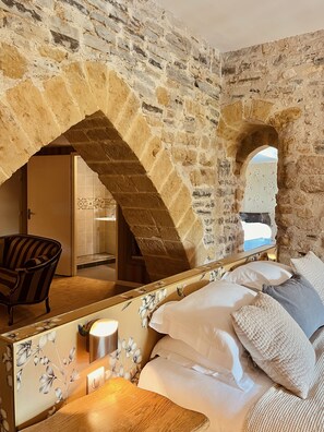 A bedroom with stone walls, a wooden bed, and a chair. - Hôtel des Basses Pyrénées (Bayonne)