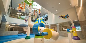 A children's play area with colorful structures and a blue carpet. - Hotel Sporting - Family Hospitality (Livigno)