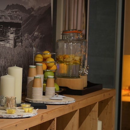 A buffet setup with various food items, including fruits and desserts, arranged on a wooden table.