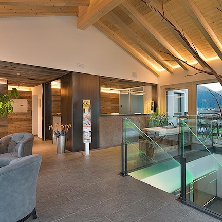 A modern living room with a sofa, a coffee table, and a staircase leading to an upper level.