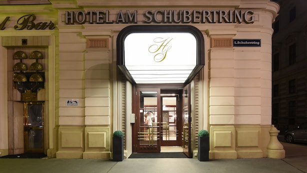 The exterior of Hotel Am Schubertring with a prominent illuminated 'H' sign, a bar entrance, and a street address sign. - Hotel Am Schubertring (Vienna)