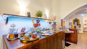 A buffet counter with various food items and a sign indicating the availability of olive bruschetta and caprese salad. - Hotel Am Schubertring (Vienna)