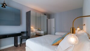 A modern hotel room with a large bed, a desk, and a wardrobe. - Residence Ten Suite (Rimini)