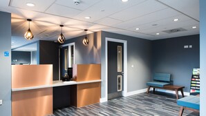 A reception area with a counter, seating, and a patterned floor. - University of Bath Guest Accommodation (Bath)