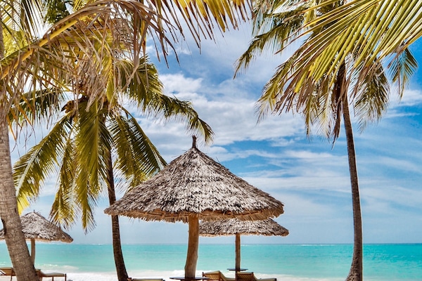 En la playa, sillas reclinables de playa, sombrillas, toallas de playa
