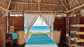 Une chambre comprenant un lit, une table, des chaises et une étagère avec des articles de toilette.