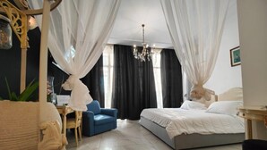 A bedroom with a bed, a desk, a chair, and a chandelier. - Aparthotel dei Mercanti (Milan)
