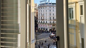 A view of a street with buildings, including a prominent 'GUCCI' sign on a building. - Aparthotel dei Mercanti (Milan)