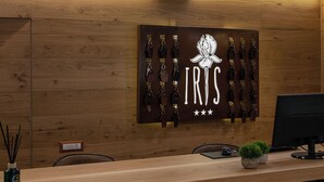 A wooden wall with a sign reading "IRIS" and a series of keys hanging below it. - Hotel Iris (Pescasseroli)