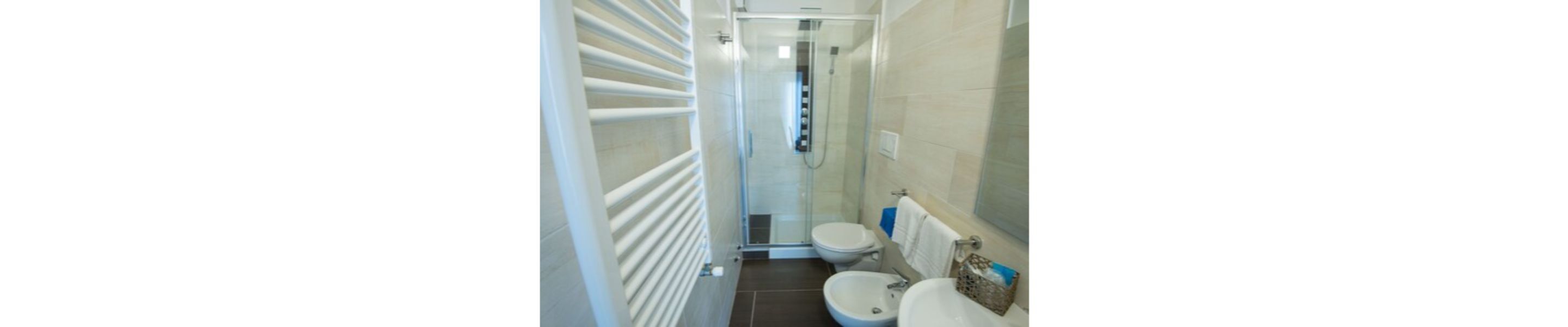 Un baño pequeño con ducha, inodoro y lavamanos.