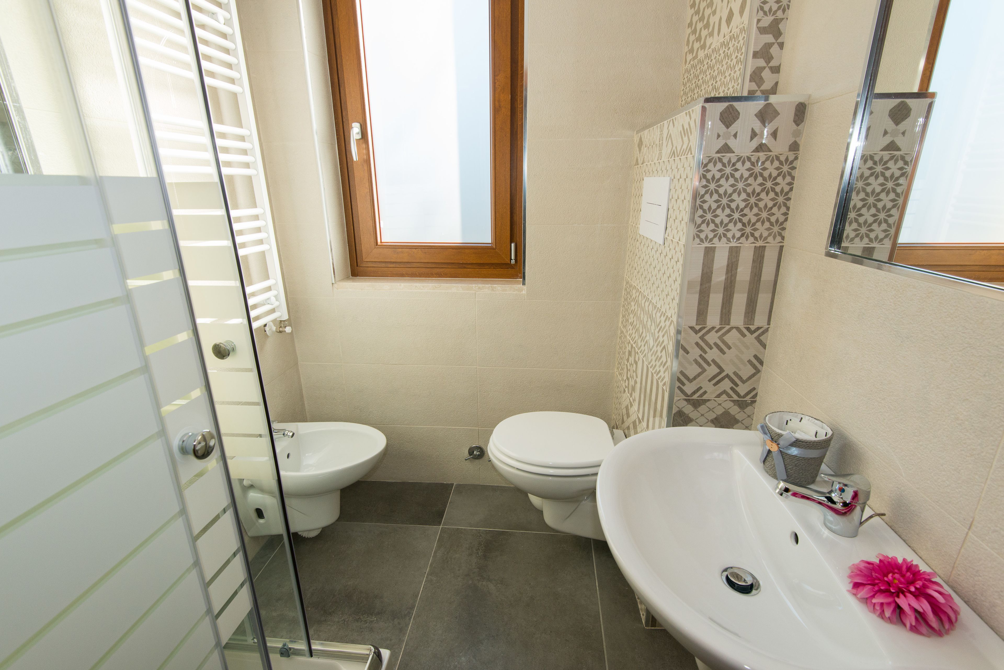 Une salle de bain comprenant des toilettes, un bidet et un lavabo.